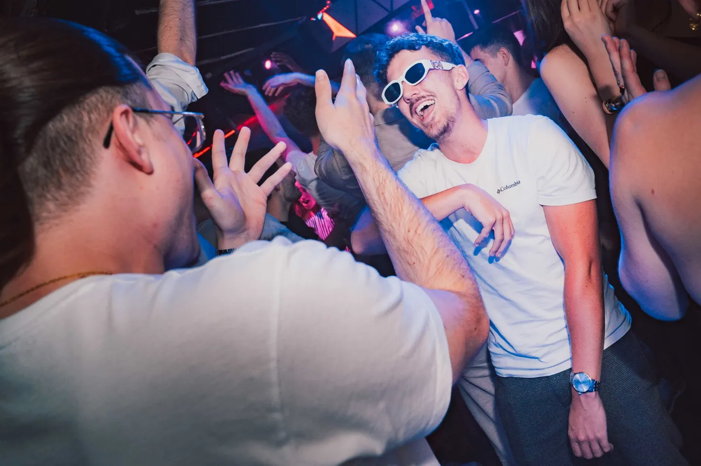 Participants faisant la fête sous les lumières d’une soirée en discothèque