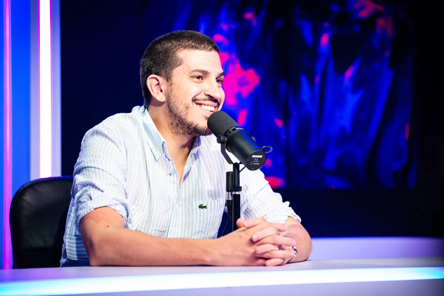 Commentateur souriant devant son microphone lors d’un événement