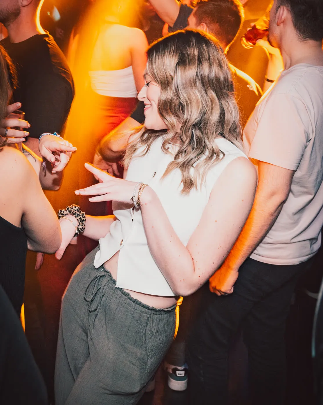 Participants discutant au milieu d’une soirée éclairée de couleurs chaudes