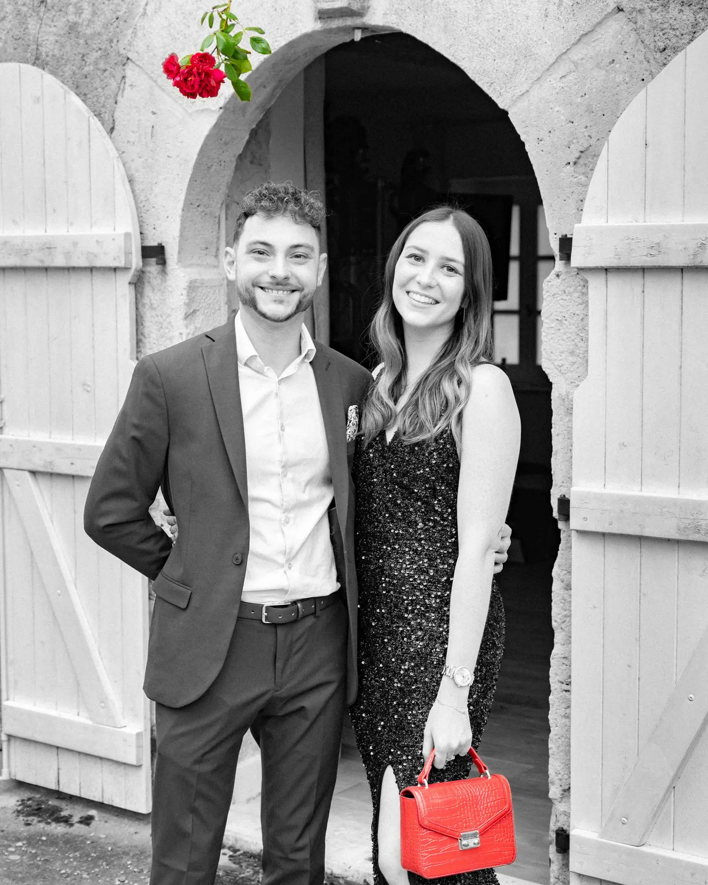 Couple sous une arche en pierre, photographié en noir et blanc