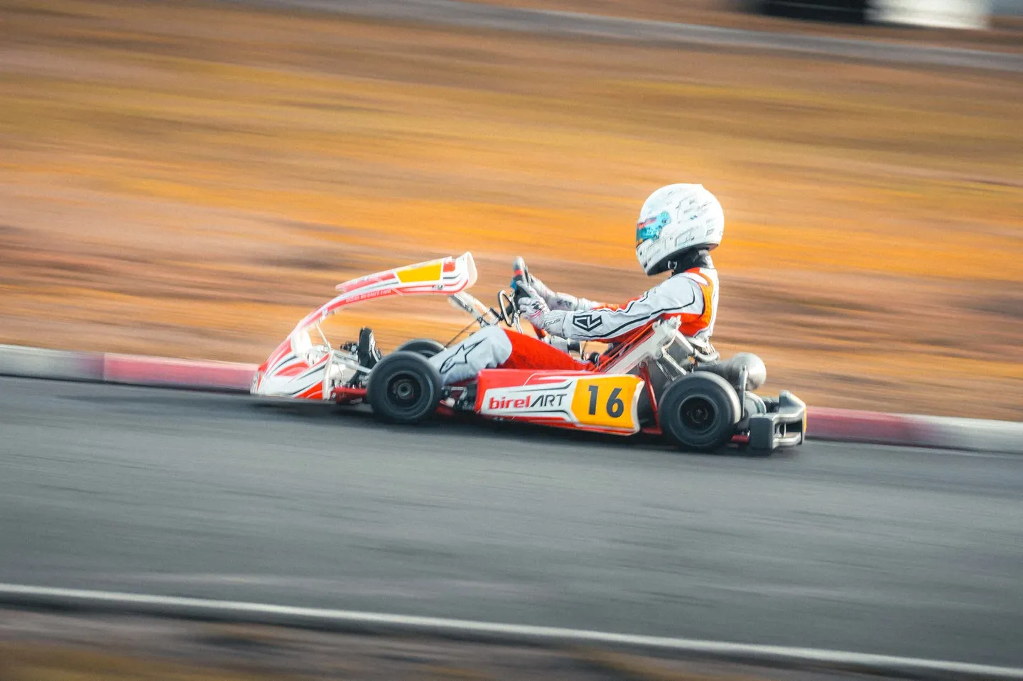 Pilote de kart en pleine course, photographié avec un effet de filé