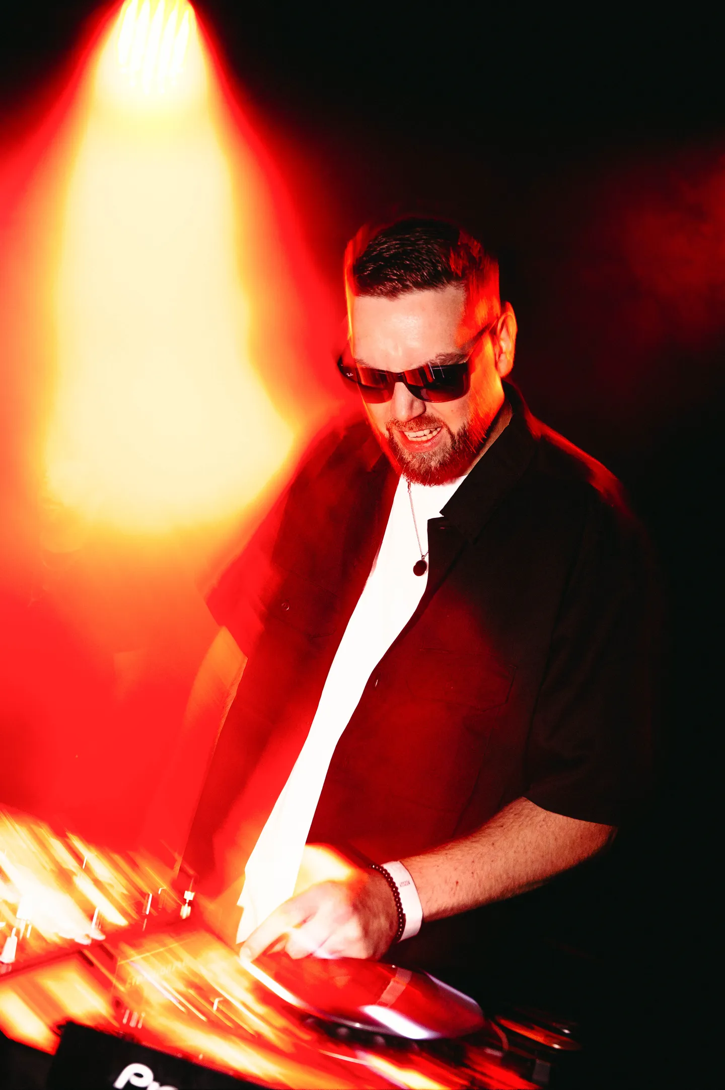 DJ aux platines sous un éclairage rouge et orange